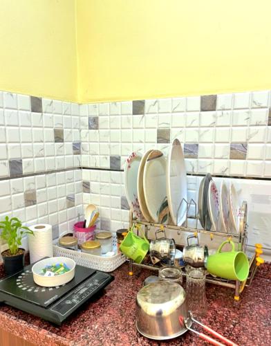 a kitchen counter with a bunch of dishes at TT Homes Private Studio Suites Jaipur Pink City in Jaipur