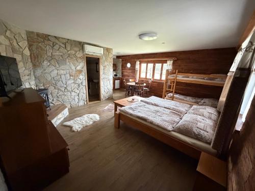 a bedroom with a large bed and a stone wall at BUBLA CITY RANCH in Kopřivnice