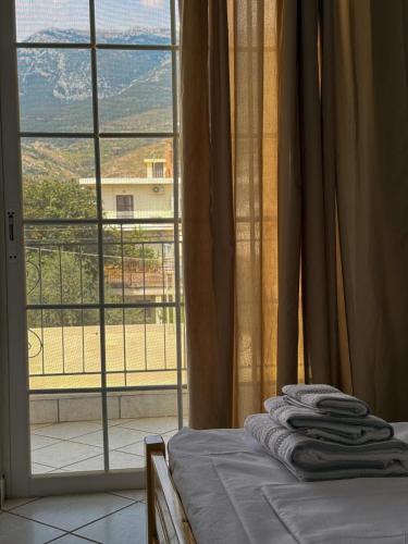 a bed in a room with a large window at Pelekanos Apartment in Paralia Saranti