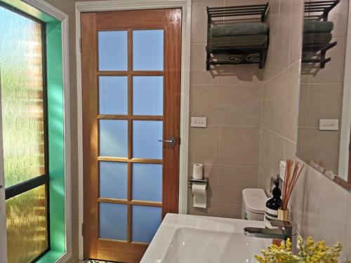 a bathroom with a tub and a toilet and a window at Creekside Cottage - Private Studio with Mountain View in Coffs Harbour