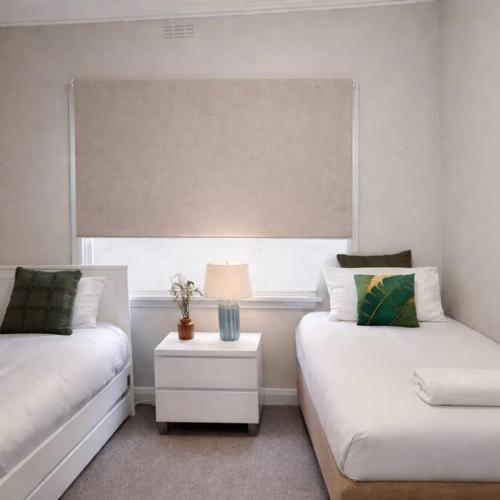 a bedroom with two beds and a table with a lamp at Hidden Gem - St Mary's in Saint Marys
