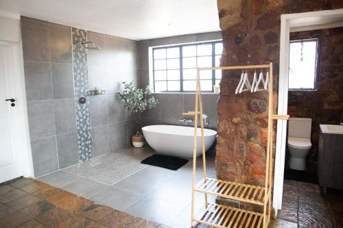 a bathroom with a tub and a shower and a sink at Die Kliphuis in Klerksdorp