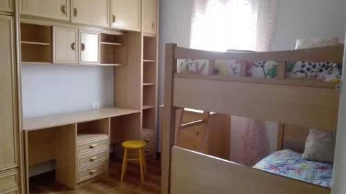 1 dormitorio con 2 literas y un taburete amarillo en Entre els pirineus, en La Seu d'Urgell