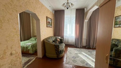 a living room with a chair and a bedroom at Гостиница Орал in Zhezdi