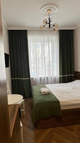 a bedroom with a bed and a table and a window at Гостиница Орал in Zhezdi
