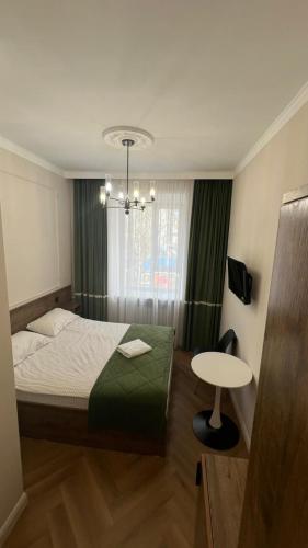 a small bedroom with a bed and a table at Гостиница Орал in Zhezdi