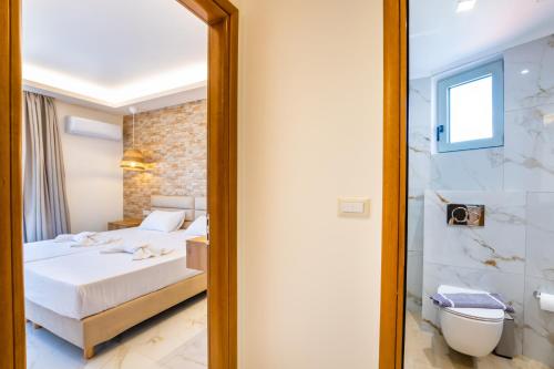 a bedroom with a bed and a shower and a mirror at Dolphin Hotel Apartments in Karpathos