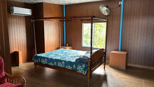 a bedroom with a canopy bed and a window at Athulya Tropical Paradise in Paravūr