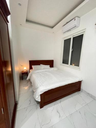 a white bedroom with a bed and a window at Anna's House - Hoa Lư in Ninh Binh