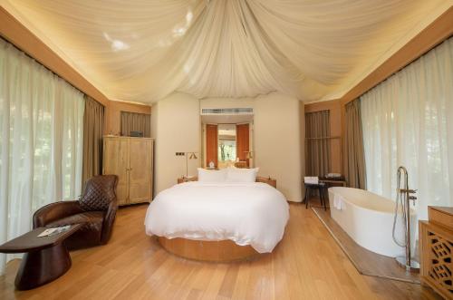 a bedroom with a large bed and a bath tub at Evergreen Forest Retreat Zhangjiajie, Near National Forest Park Avator Park, Luxury Nature Escape, Free Airport&Train Shuttle Service & Travel itinerary, English Speaking Butler in Zhangjiajie