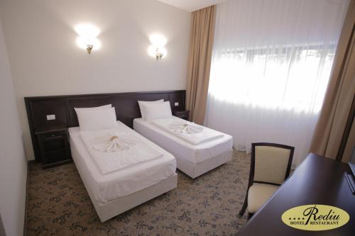 a hotel room with two beds and a window at Rediu Hotel & Restaurant in Botoşani
