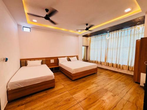 two beds in a room with wooden floors at Fairview Anayaa in Khātu