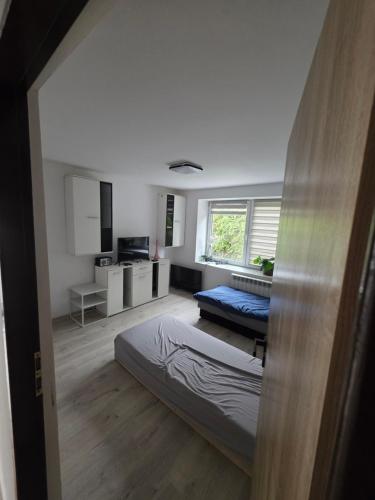a room with two beds and a tv in it at Noclegi Pracownicze Niepołomice in Niepołomice