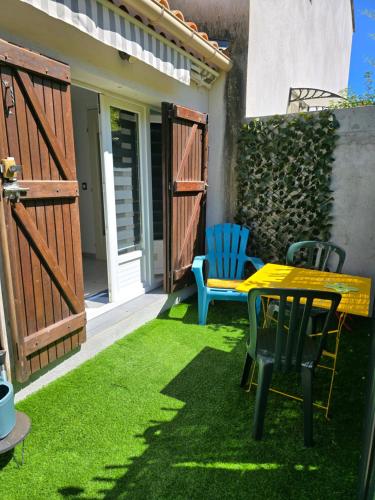 a patio with a table and chairs on the grass at Studette avec terrasse privée in Saint-Raphaël
