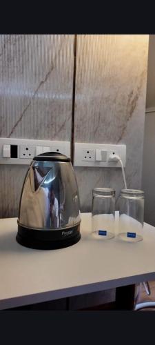 a toaster sitting on top of a counter with two glasses at Harmony Hills in Bhīra Camp