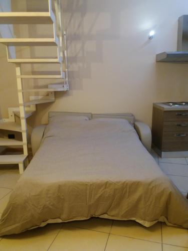 a bed in a small room with a staircase at Villa Cocuzza in Piozzo