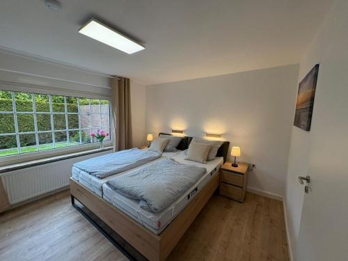 a bedroom with a large bed and a window at Achterdeck Kajüte in Dornumersiel