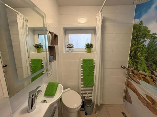 a bathroom with a sink and a toilet and a window at Achterdeck Kajüte in Dornumersiel