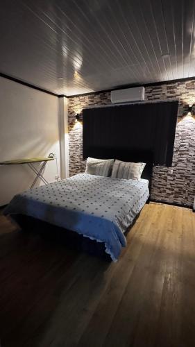 a bedroom with a bed and a brick wall at Raza villa in Lautoka