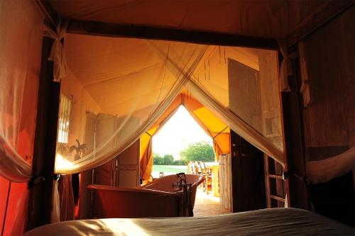 a view of a tent with a bed in it at Kimaro Farmhouse in Colméry