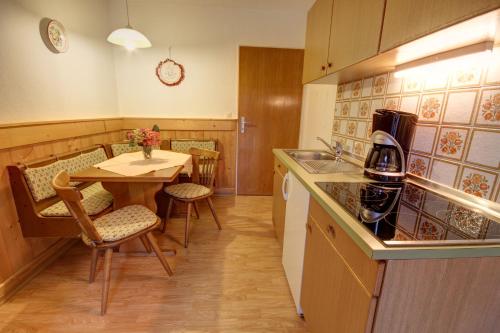 a kitchen with a table and chairs and a kitchen with a counter at Ferienwohnung Haus Rieder Inzell in Inzell