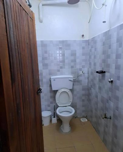 a bathroom with a white toilet in a stall at Esskayhomestays in Eldoret