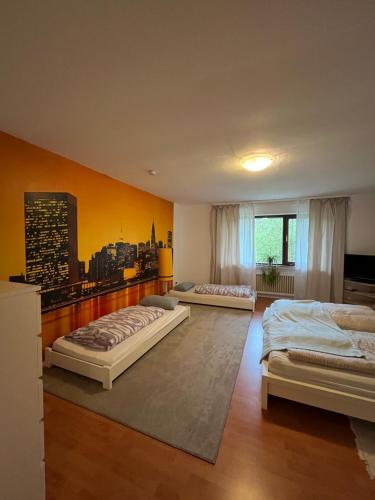 two beds in a bedroom with a city mural on the wall at Gemütliche Ferienwohnung mit Blick ins Grüne in Wadern