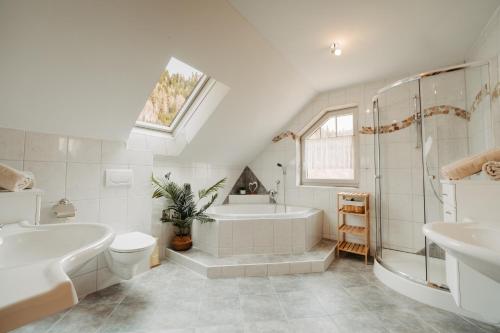 a white bathroom with a tub and a sink at Landhaus Zitz in Ranten