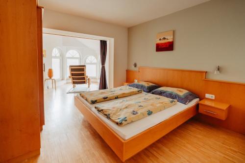 a bedroom with a bed and a chair in it at Landhaus Zitz in Ranten