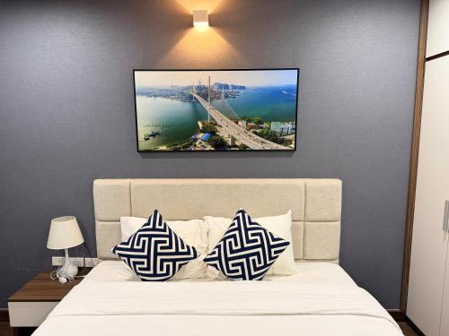 a bed with two blue and white pillows on it at Ha Long 2BR Apartment - Spacious & Modern - Near Center in Ha Long