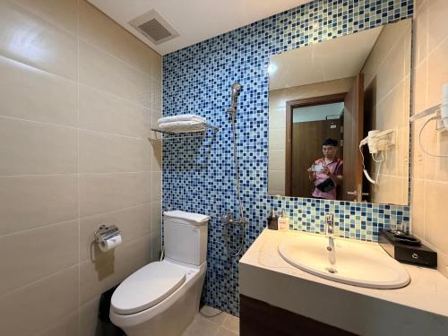 a bathroom with a toilet and a sink and a mirror at Ha Long 2BR Apartment - Spacious & Modern - Near Center in Ha Long