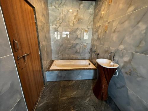 a bathroom with a tub and a sink and a toilet at Fairview Anayaa in Khātu