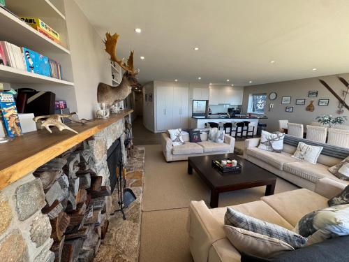 a living room with couches and a stone fireplace at Mark II 3W in Mount Buller