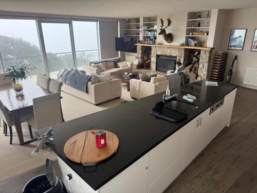 a living room with a table and a living room with a fireplace at Mark II 3W in Mount Buller
