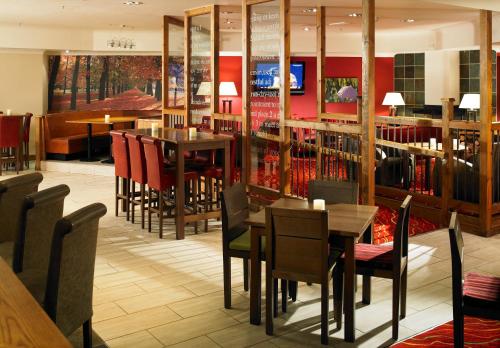 a restaurant with tables and chairs and a library at Hollins Hall Hotel, Golf & Country Club in Bradford