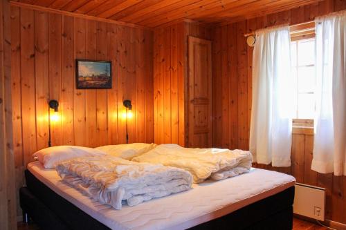 a bedroom with a large bed in a wooden wall at Haugsynlies sjarm in Beitostøl
