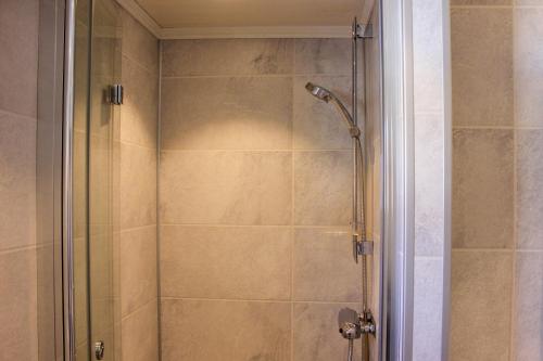 a shower with a glass door in a bathroom at Haugsynlies sjarm in Beitostøl