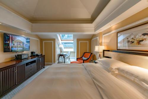 a large bedroom with a large bed and a television at Hangzhou Rose Garden Resort & Spa in Hangzhou