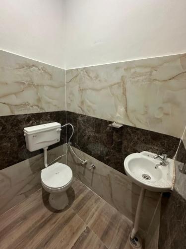 a bathroom with a toilet and a sink at Anmol Hotel And Restaurant in Chandausi