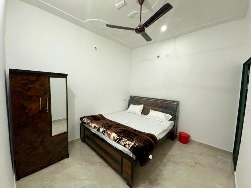 a bedroom with a bed and a ceiling fan at Anmol Hotel And Restaurant in Chandausi