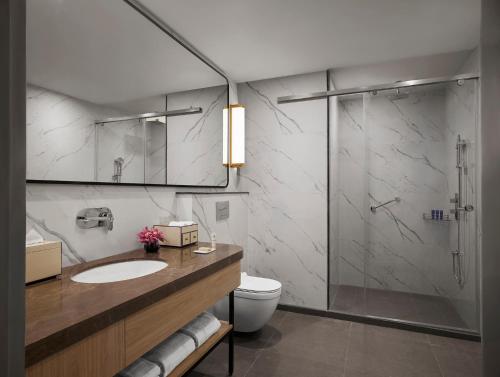 a bathroom with a shower and a toilet and a sink at Vivanta Ekta Nagar in Kevadia