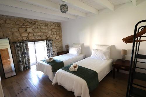 a bedroom with two beds and a stone wall at The Monet in Châteauneuf-sur-Charente