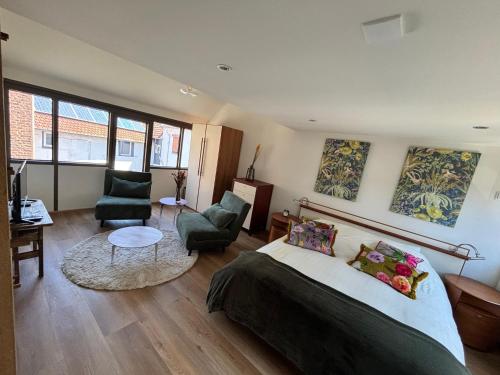 a bedroom with a bed and a living room at D'r Preëksjtool in Eygelshoven