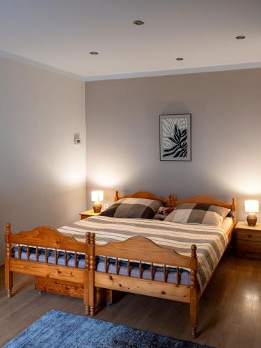 a bedroom with a large wooden bed with two lamps at Apartment Sučany in Sučany
