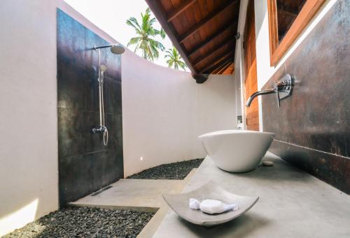 uma casa de banho com um lavatório e uma banheira em Sanjis The Seaside Cabanas em Tangalle