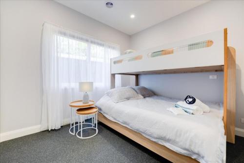 a bedroom with a bunk bed and a table at Wilson's Beach Beauty in Inverloch