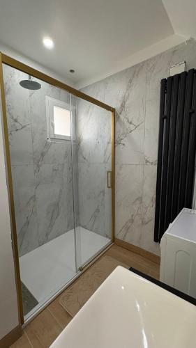 a shower with a glass door in a bathroom at rozormant in Rosporden