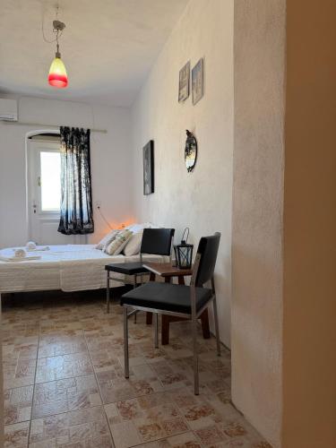 a bedroom with a bed and two chairs and a table at Patrick's Traditional Home in Pyrgi