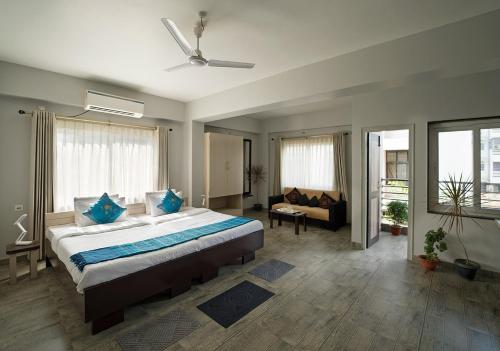 a bedroom with a large bed and a couch at Happy Villa Guest House in Guwahati