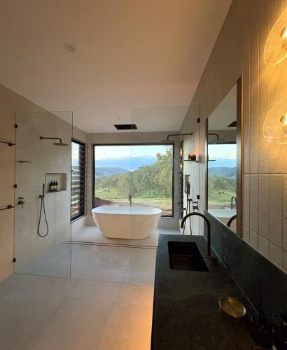 a large bathroom with a tub and a large window at Silk & Oak in Darlington